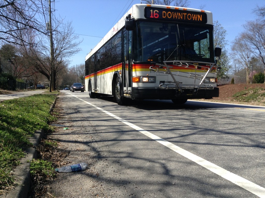 Poorly designed and maintained bike lane. This debris-filled bike lane is 4-feet wide with barely 12 inches of usable road surface just right of the white line, squeezing bicyclists up against traffic that includes wide buses. Peace Street, Raleigh, NC. Photo: George Hess.