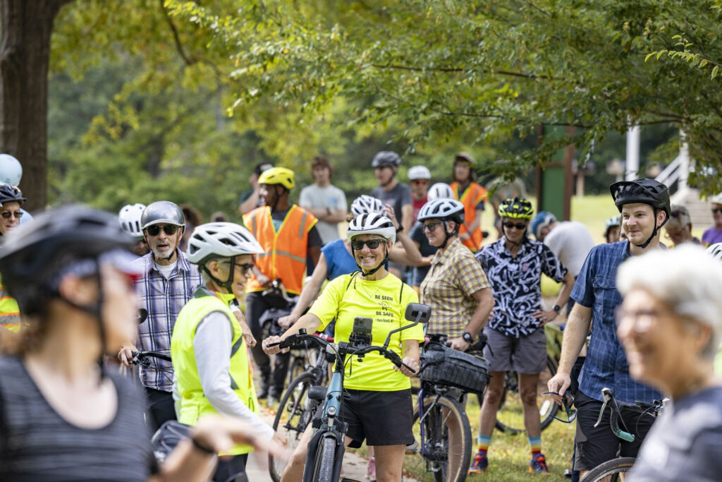 a group of people wearing helmets gathered on bicycles
